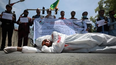 An Afghan man wearing posing as a dead body lays down on a road as protesters shout slogans against the Iranian regime and demand justice during a protest outside the Iranian Embassy in Kabul, Afghanistan, 07 May 2020. EPA