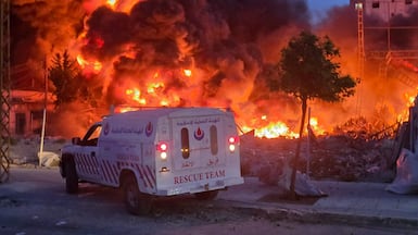 An ambulance is parked near a sweeping blaze following Israeli bombardment on Lebanon's southern coastal city of Tyre. AFP.