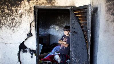 A boy stands amid the rubble of the home in Hebron of Marwan Qawasmeh, one of two Hamas members named by Israel as prime suspects in the murder of three kidnapped Israeli teenagers, which was destroyed by the Israeli army on July 1, 2014. Ahmad Gharabli / AFP