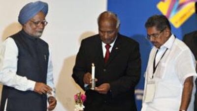 Manmohan Singh, the Indian prime minister, left, and Vayalar Ravi, the minister for overseas Indian affairs, right, watch as Ramidien Sardjoe, the Surinam vice-president, lights an oil lamp during the Pravasi Bharatiya Divas.