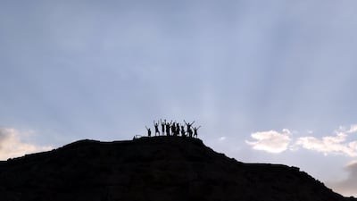 Explorers cheer from the top of a hill after cutting a new trail in Wadi Billi, Egypt. Reuters