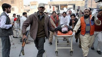 Hospital security staff and volunteers rush people who were injured in twin-suicide bomb blasts in Mohmand tribal region, to a local hospital for medical treatment in Peshawar.
