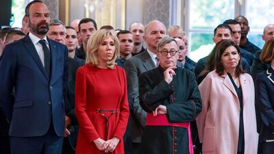 French Prime Minister Edouard Philippe, left, French President 's wife Brigitte Macron, second left, Archibishop of Paris Jean-Marc Chauvet and Paris mayor Anne Hidalgo listen to French President Emmanuel Macron addressing Paris Firefighters' brigade and security forces who took part at the fire extinguishing operations of the Notre Dame of Paris Cathedral fire, at the Elysee Palace in Paris, Thursday, April 18, 2019. France paid a daylong tribute Thursday to the Paris firefighters who saved the internationally revered Notre Dame Cathedral from collapse and rescued many of its treasures. AP
