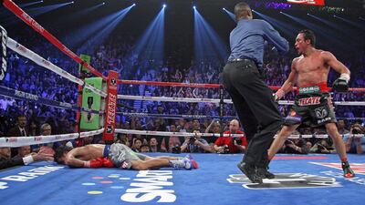Referee Kenny Bayless holds back Marquez as Manny lies face down on the mat after being knocked out. AFP PHOTO / John Gurzinski