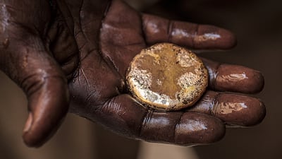 A jeweller in Khartoum holds a piece of gold in the palm of his hand. AFP
