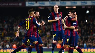 Lionel Messi, far right, and his Barcelona teammates celebrate after they score the opening goal in a 5-1 win over Sevilla on Saturday in La Liga. David Ramos / Getty Images / November 22, 2014