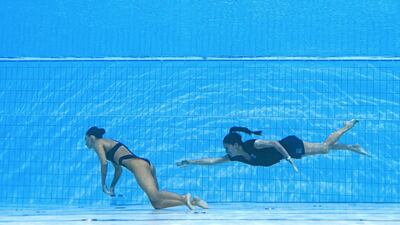 A member of Team USA goes to help Anita Alvarez who has fainted during the women's solo free artistic swimming finals during the World Aquatics Championships at the Alfred Hajos Swimming Complex in Budapest, on June 22, 2022. AFP