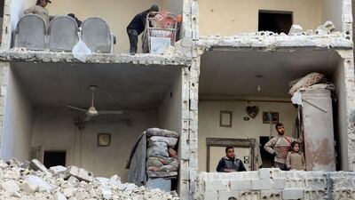 Civilians in a damaged building in Syria's northern city of Aleppo following a reported air strike by government forces on December 7. AFP Photo