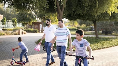 Mfadi Al Jasser, right, with his brother and sons in Heritage Park on Abu Dhabi's Corniche.