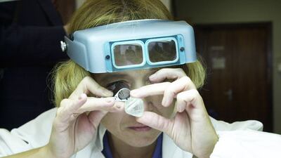 A sorter inspects a Russian diamond in Moscow. Getty