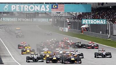 Mark Webber, front right, moves up behind Red Bull teammate Sebastian Vettel, front left, at the start the Malaysian Grand Prix.