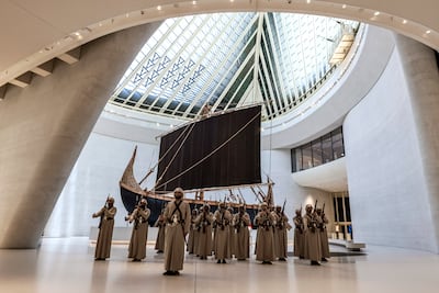 Performing troupe mark the opening of The Journey of Unity Through Time at Zayed National Museum, with a recreation of the Magan boat behind them. Victor Besa / The National