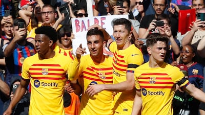 Ferran Torres, second left, celebrates with his Barcelona teammates after scoring against Atletico Madrid. EPA