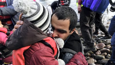 A man hugs a child upon their arrival at the village of Skala Sikaminias, on the Greek island of Lesbos, after crossing the Aegean sea from Turkey. AP
