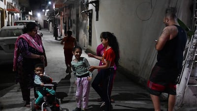 Residents gather outside their homes in Amritsar. AFP
