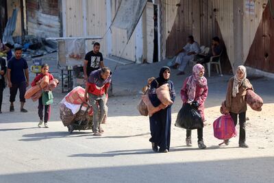 Palestinians carry their belongings as they flee Israeli bombardment in the north of Gaza on October 12, 2024. AFP
