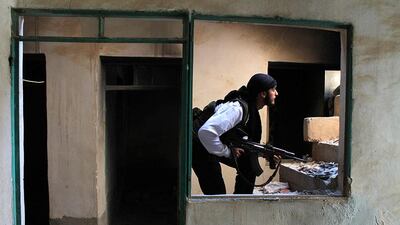 An opposition fighter guards a position in the Jubaila neighbourhood of the northeastern city of Deir Ezzor, Syria. Ahmad Aboud / AFP