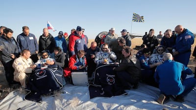 US astronaut Nick Hague, Russian cosmonaut Alexey Ovchinin, and UAE astronaut Hazzaa Ali Almansoori, sit in chairs shortly after landing. AP Photo
