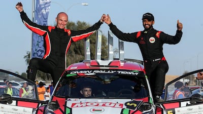Oman's Abdullah al-Rawwahi (R) and co-driver Ata al-Hmoud celebrate after winning second place during the Oman International Rally in Muscat. AFP