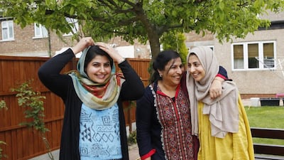 Sundas, her mother Naheed, and sister Shanza, pose for a photograph after an interview with Reuters, at home in Walthamstow, east London. Sundas and Shanza started wearing the headscarf or hijab in opposition to their parents’ wishes, particularly from their mother, who doesn’t cover her head and didn’t like their strict interpretation of Islam.