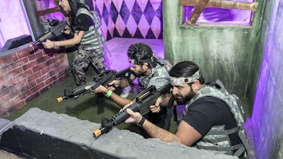 An Xstrike session is like a workout, as players must be quick on their feet, handle heavy equipment and dodge shots by ducking, squatting and hiding. Photo: Antonie Robertson / The National