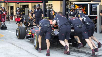 Crew members push Verstappen's car in the pits. Christopher Pike / The National
