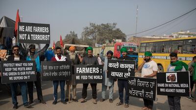 Protesting farmers hold placards at the border between Delhi and Haryana state. Talks between protesting farmers and the Indian government failed. AP