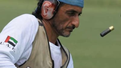 The Emirati shooter Sheikh Ahmed bin Hasher empties cartridges from his rifle during qualifying yesterday.