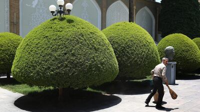 A groundskeeper sweeps in the garden of the Contemporary Art Museum Isfahan. John Moore / Getty Images