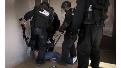 An Israeli riot policeman kicks a Palestinian man before detaining him during riots in the East Jerusalem neighborhood of Issawiya on May 13. A report by an Israeli civil liberties group has accused Israeli police of bias and using excessive force against Palestinians in Jerusalem. Marco Longari / AFP