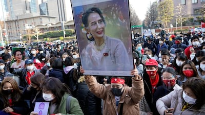 A Myanmar national in Japan holds up a portrait of Aung San Suu Kyi during a protest held in front of the United Nations University in Tokyo. EPA