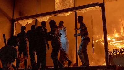 People in front of the burning Daily Star newspaper building in Bangladesh's capital, Dhaka, amid protests over the death of youth leader Sharif Osman Hadi. AFP