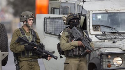 Israeli security forces stand guard as they prevent Palestinians from approaching the area where Ahmed Ikmel, 16, was killed on Saturday after he allegedly attempted to stab a private security guard at the Al Jalama checkpoint in the northern West Bank. Majdi Mohammed/AP Photo