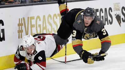 Arizona Coyotes center Clayton Keller and Vegas Golden Knights defenseman Brayden McNabb fall to the ice during the second period of an NHL hockey game in Las Vegas. John Locher / AP Photo