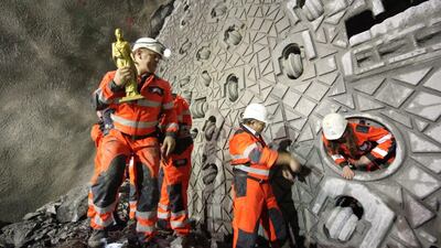 A miner holding a statue of Saint Barbara front of the drilling machine ‘Gabi 2’ in the Gotthard Base Tunnel. The excavation work has taken more than 15 years. Urs Flueeler / EPA