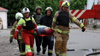 Rescues carry a person wounded by a Russian missile strike in Dnipro. Reuters