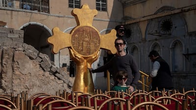 Omar Qais, an Iraqi sculpture, stands in front of the cross he made that is on the platform where Pope Francis will make a prayer on Sunday, March, 7, 2021, in Mosul. Courtesy Ali Al Baroodi.
