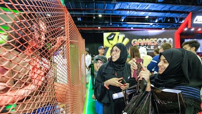 Visitors to the Middle East Film & Comic Con take photos of Kirsten Beers, dressed as the girl zombie from the video game State of Decay Year One. Victor Besa for The National.