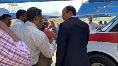 The Consul General of India in Dubai, in black suit helping relatives and friends. Pawan Singh / The National