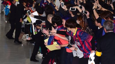 Japanese fans line the barriers at Narita Airport as the Barcelona squad arrive for the Club World Cup. Yoshikazu Tsuno / AFP
