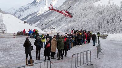 Tourists wait in line to be airlifted by helicopter after being trapped by heavy snowfall in Zermatt, Switzerland. Dominic Steinmann / Keystone via AP