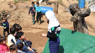 Nejmeh, 13, addresses her class in a Syrian refugee camp in Ketermaya, Lebanon. She is one of two young girls in this camp who acts as a teacher for younger children. Josh Wood for The National