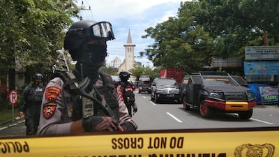 Armed police officers stand guard along a closed road following an explosion outside a Catholic church in Makassar, South Sulawesi province, Indonesia. Antara Foto / Reuters