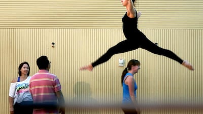 Emily Golding-Ellis leaps during a floor-mat routine at a gymnastics session for grown-ups. In Abu Dhabi, Little Stars Gymnastics Club and Jump Sports Academies offer classes. Delores Johnson / The National
