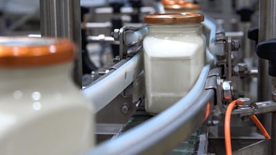 Bottles of just-filled spreadable cheese on their way to get labelled on the automated production line. Victor Besa / The National