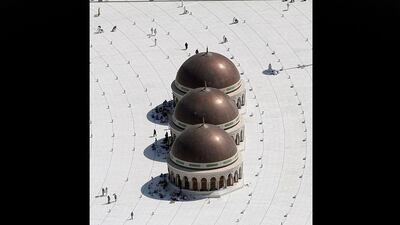 People sit in the shade before heading to pray in the Grand Mosque during the annual Haj in the holy city of Mecca, Saudi Arabia. Hassan Ammar / AP Photo
