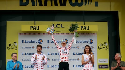 UAE Team Emirates' Tadej Pogacar celebrates on the podium wearing the polka-dot jersey after stage 13. Reuters