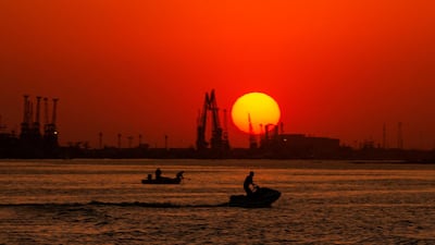 A boat sails and a man rides a jet ski along the Shatt Al-Arab river in the southern Iraqi port city of Basra. AFP