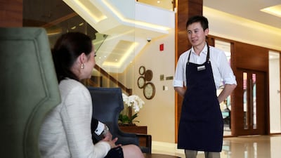 A waiter speaks to a guest at The Radisson Blu hotel in Business Bay area in Dubai. The hotel has banned staff from using formal greetings. Pawan Singh / The National