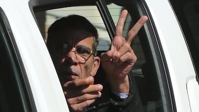 Seif Eddin Mustafa flashes the victory sign from inside a police car after leaving court for a remand hearing on March 30, 2016. Petros Karadjias, File / AP Photo